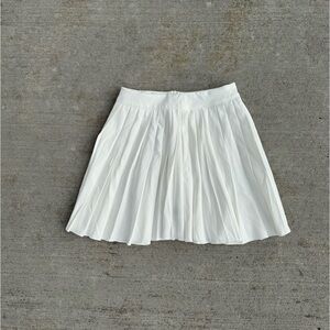 White pleated tennis skirt with elastic waistband and zipper closure